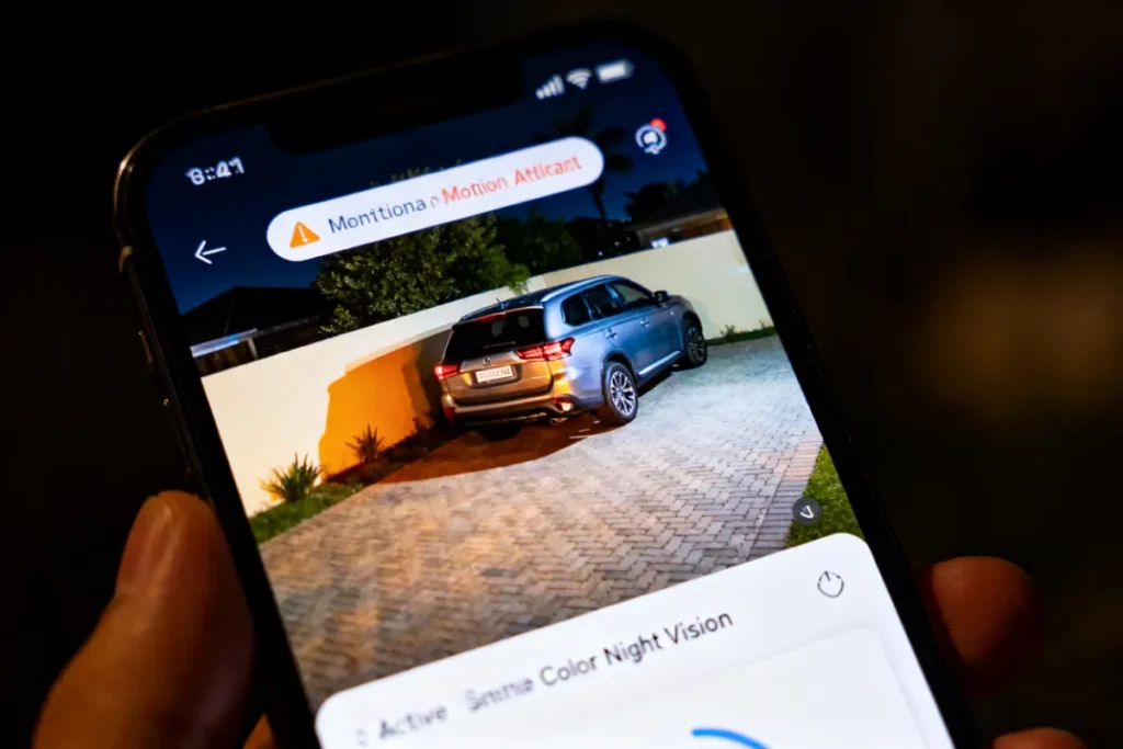 Smartphone showing live colour night vision footage from an outdoor solar security camera on a South African driveway
